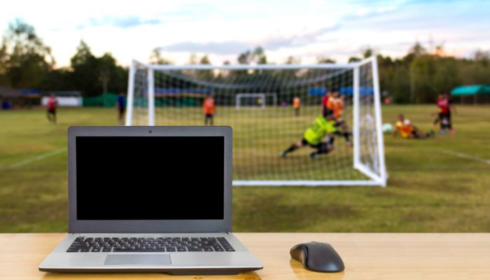 Laptop in front of football game