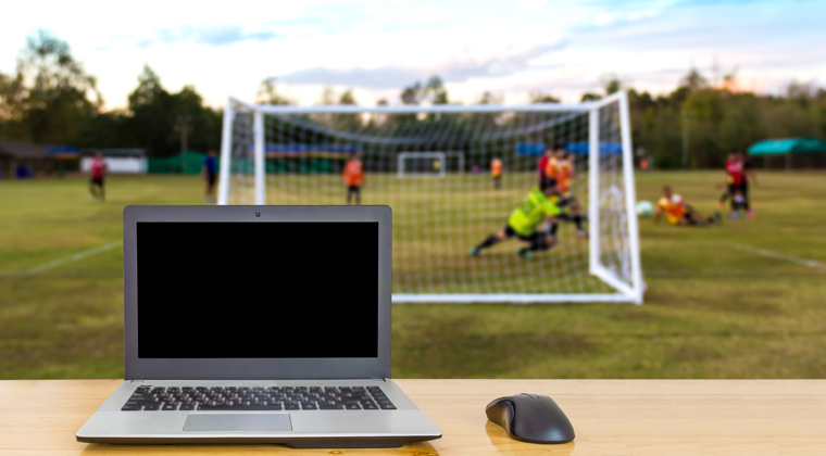 Laptop in front of football game